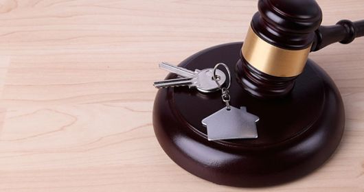 marteau de loi et clés de maison sur un bureau