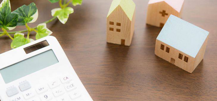 bureau avec maisons miniatures et une calculatrice