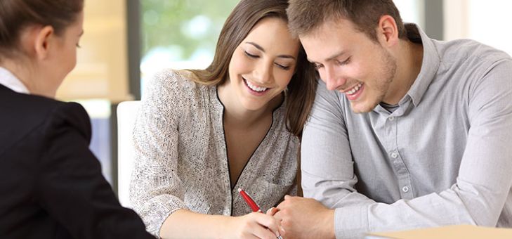 couple heureux qui signe le contrat immobilier