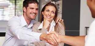 serrage de mains entre agent immobilier et un couple