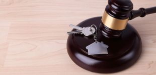 marteau de loi et clés de maison sur un bureau